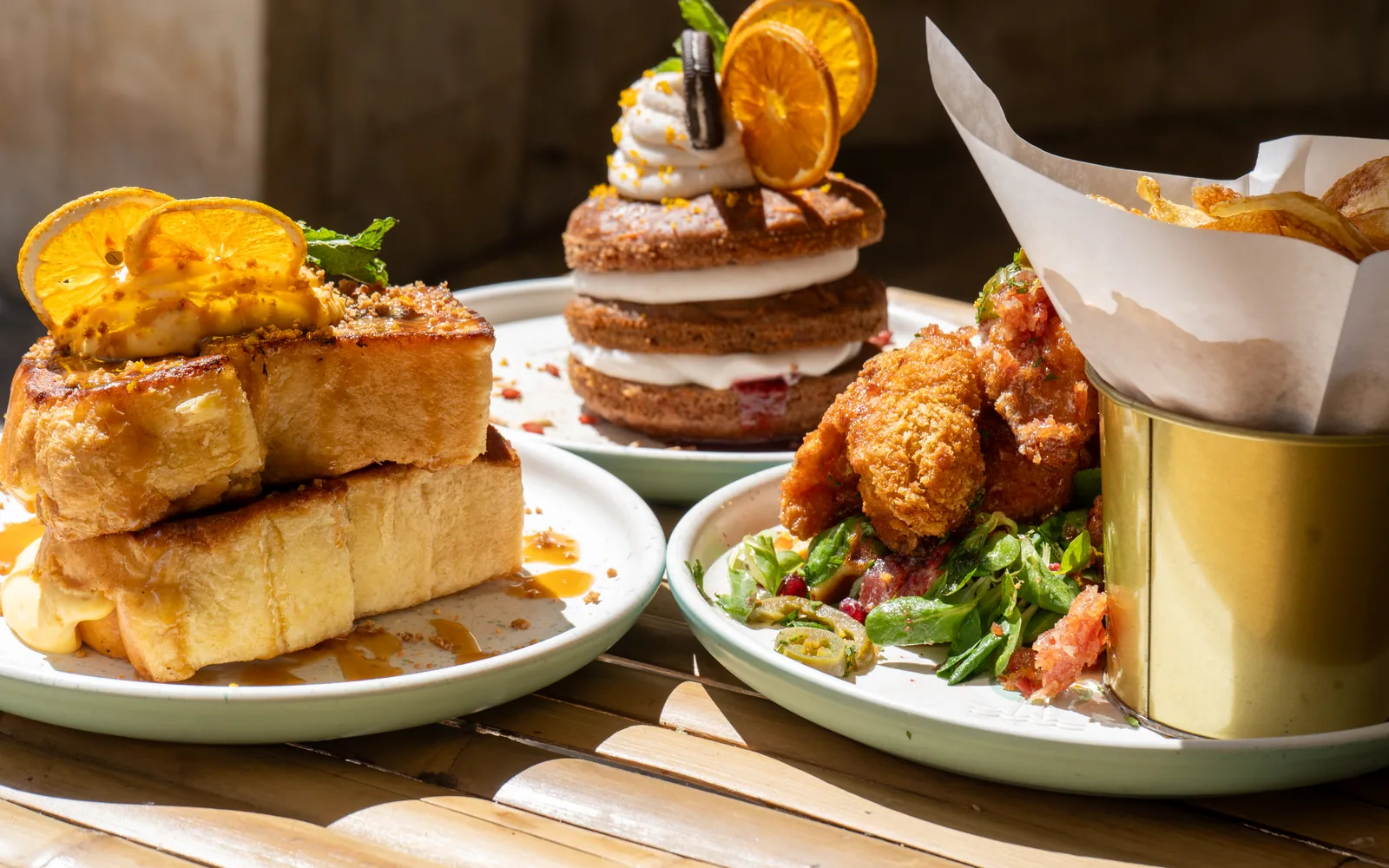 A shared brunch table at Cookie Beacon: French toast, a carrot-cake pancake stack and a chicken and waffles stack
