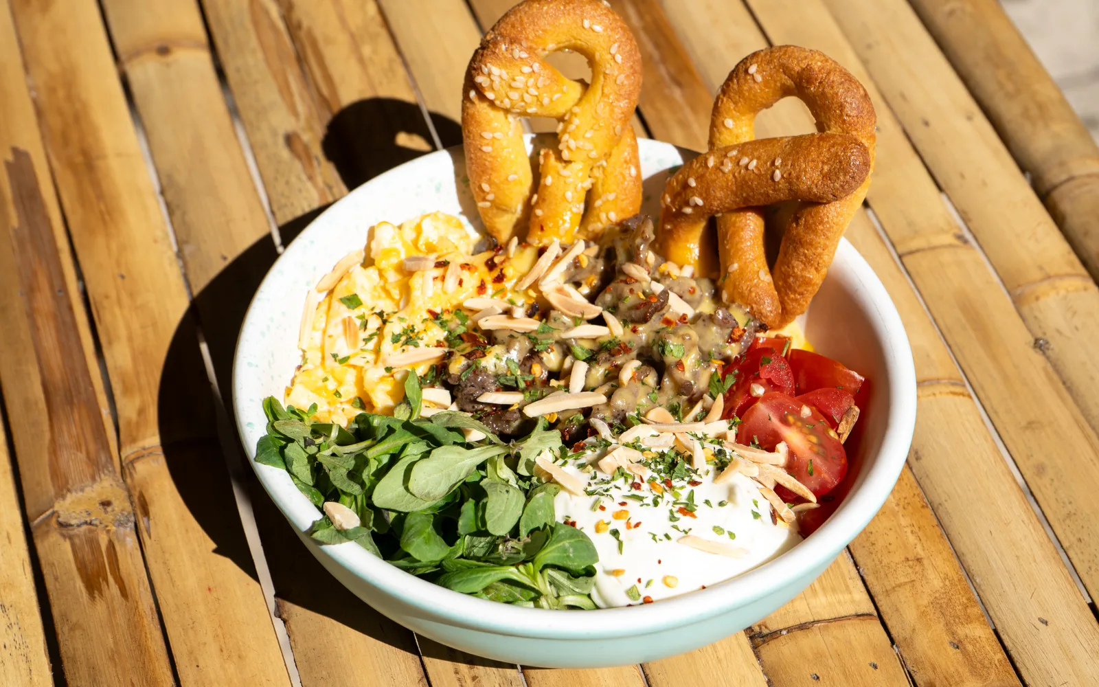 Philly Cheese Steak Protein-Bowl with scrambled eggs, sirloin in cheese sauce, sour cream and sesame keto pretzels, a Cookie Beacon brunch plate