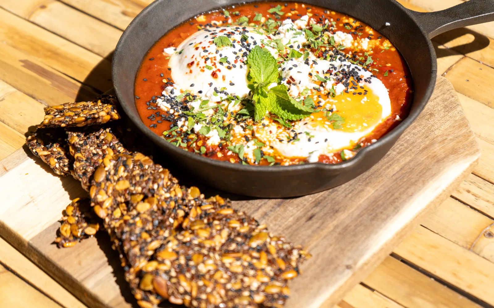 Shakshuka Burrata, eggs in a spiced tomato and pepper sauce with seed crackers, at Cookie Beacon Budapest