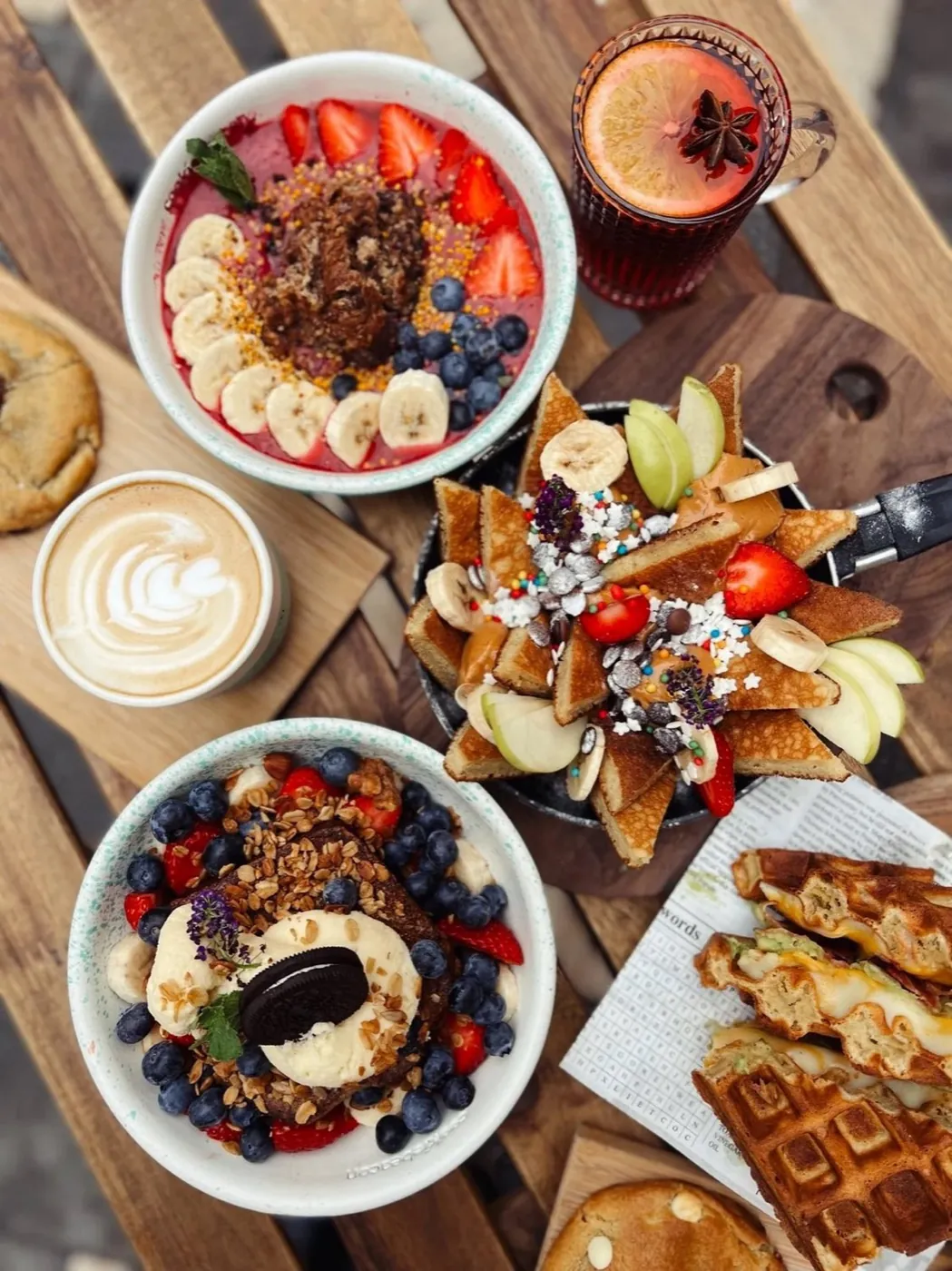 Hearty brunch topped with fresh fruit, nuts and chocolate, with a flat white at Cookie Beacon