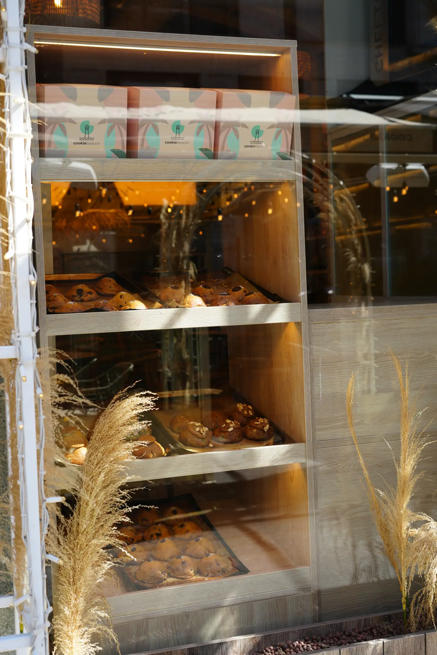 Trays of chunky cookies on lit shelves behind the window at Cookie Beacon Kralja Petra in Belgrade