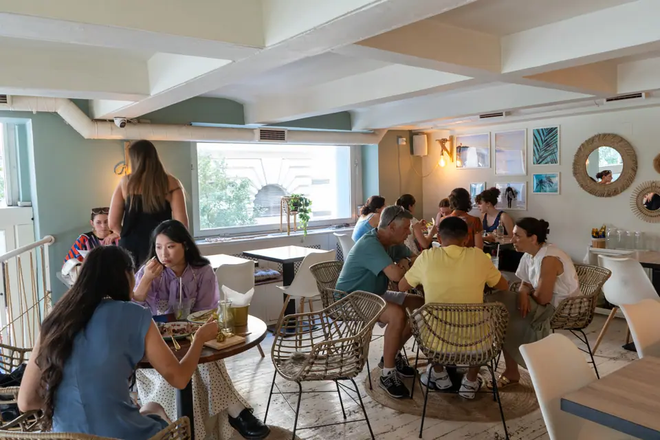 Guests eating brunch at long tables in the upstairs room at Cookie Beacon Budapest