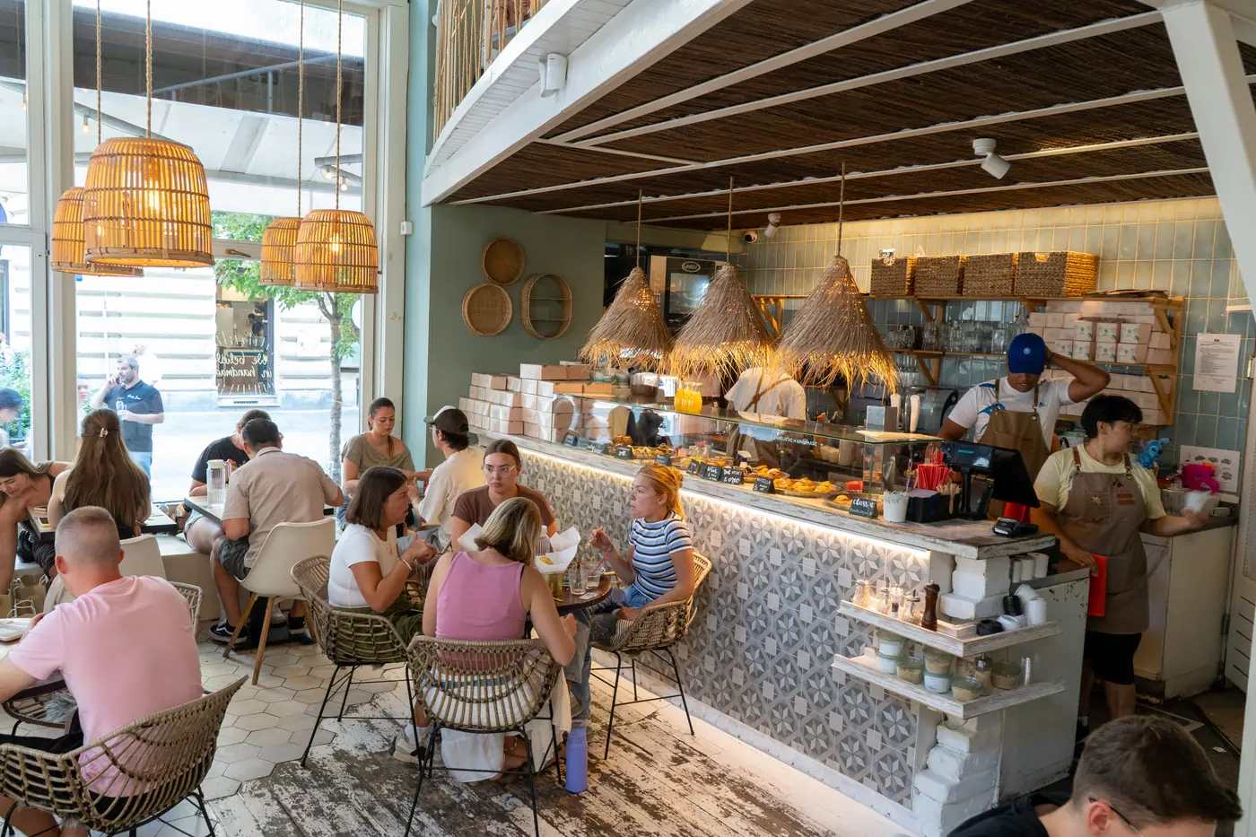 Baristas at work behind the tiled service counter at Cookie Beacon Basilica