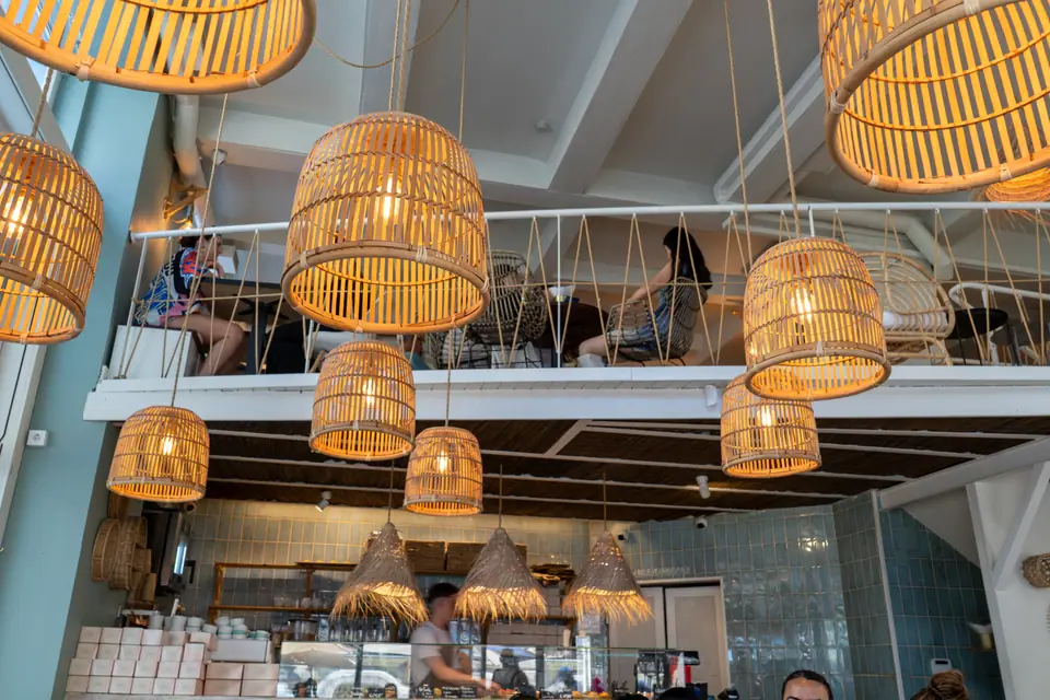 The cluster of woven rattan pendant lamps hanging over the ground floor of Cookie Beacon Budapest